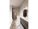 Modern bathroom with marble floors, gray vanity, double sinks, and a stylish, frameless glass shower at 1772 Eisenhower, Louisville, CO 80027