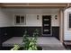 Inviting covered front porch with modern black accent door and updated light fixtures at 1772 Eisenhower, Louisville, CO 80027
