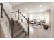 Sunlit living room features hardwood floors and staircase with charming modern decor at 1772 Eisenhower, Louisville, CO 80027