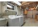 Functional laundry room with washer, dryer, utility sink, and storage cabinets in the basement at 12020 W Center Ave, Lakewood, CO 80228