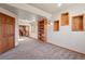 Cozy basement area featuring carpet floors, a built-in bookshelf and decorative wall insets at 8493 S Newcombe Way, Littleton, CO 80127