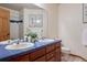 Bathroom with blue tile countertop, double sinks and a tiled bath and shower combination at 8493 S Newcombe Way, Littleton, CO 80127