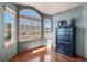 Bright bedroom showcasing hardwood floors and large windows with community views at 8493 S Newcombe Way, Littleton, CO 80127