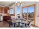 Cozy breakfast nook features a glass table and views of the deck and mountain landscape at 8493 S Newcombe Way, Littleton, CO 80127