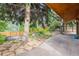 Landscaped backyard with stone patio, mature trees, and raised garden beds, creating a serene outdoor space at 8966 Sunridge Hollow Rd, Parker, CO 80134