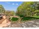 Lush backyard featuring a stone pathway, mature trees, and a patio area for relaxing and enjoying the outdoors at 8966 Sunridge Hollow Rd, Parker, CO 80134