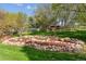 Landscaped backyard featuring decorative metal art, complemented by lush greenery and rock features for visual appeal at 8966 Sunridge Hollow Rd, Parker, CO 80134