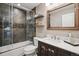 Bathroom with a tiled shower, modern vanity, and framed mirror at 8966 Sunridge Hollow Rd, Parker, CO 80134