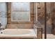 Close up of the tub and shower in the bathroom featuring beautiful decorative tiling at 8966 Sunridge Hollow Rd, Parker, CO 80134