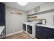 Laundry room with modern washer and dryer, stylish navy cabinetry, and designer tile backsplash at 8966 Sunridge Hollow Rd, Parker, CO 80134