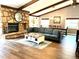Cozy living room featuring a stone fireplace, wood beams, and hardwood floors at 8966 Sunridge Hollow Rd, Parker, CO 80134