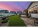 Outdoor living is easy in this backyard with a green lawn, landscaping, a deck, and stone patio under a gorgeous sky at 4555 Gray Wolf Ln, Castle Rock, CO 80104