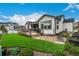Beautiful backyard featuring a pristine lawn, a spacious deck, stone patio, lush landscaping, and backyard seating at 4555 Gray Wolf Ln, Castle Rock, CO 80104