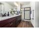 Elegant bathroom featuring double sinks with granite countertops and a modern glass shower with a dark frame at 4555 Gray Wolf Ln, Castle Rock, CO 80104