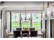 Bright dining room with a large window, modern chandelier, and seating for up to eight people at 4555 Gray Wolf Ln, Castle Rock, CO 80104