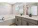 Bathroom with double vanity, soaking tub, modern fixtures, and tiled backsplash at 17962 E 94Th Pl, Commerce City, CO 80022