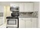 Updated kitchen with stainless steel appliances and mosaic backsplash at 2790 S Hudson St, Denver, CO 80222