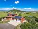 Aerial view of the home and a two car garage equipped with solar panels, surrounded by an expansive green landscape at 4586 Best Rd, Larkspur, CO 80118