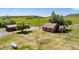 Aerial view of a charming property featuring a house, barn, and surrounding green fields with a fence at 4586 Best Rd, Larkspur, CO 80118