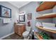 Charming bathroom with wooden vanity, granite countertop, and decorative shelves with towels at 4586 Best Rd, Larkspur, CO 80118