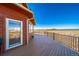Spacious deck with brown wood floor and wood railings featuring mountain and plains views at 4586 Best Rd, Larkspur, CO 80118
