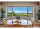 Bright dining room featuring an oval table with a beautiful view of green fields and distant mountains at 4586 Best Rd, Larkspur, CO 80118