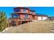 Exterior elevation showcasing a large deck, solar panels, and a two-car garage at 4586 Best Rd, Larkspur, CO 80118