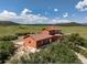 Beautiful home in a picturesque setting with a verdant field, blue skies, and distant mountain views at 4586 Best Rd, Larkspur, CO 80118