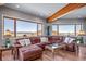 Bright living room with exposed beams, hardwood floors, and large windows with scenic views at 4586 Best Rd, Larkspur, CO 80118