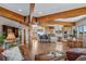 Expansive living space featuring exposed wooden beams and a view of kitchen at 4586 Best Rd, Larkspur, CO 80118