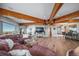 Expansive living space featuring exposed wooden beams and a view of kitchen at 4586 Best Rd, Larkspur, CO 80118
