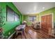 Bright room with green walls, hardwood floors, a massage table, and scenic views through a window at 4586 Best Rd, Larkspur, CO 80118