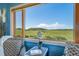 Close up of seating area with big picture windows showing the expansive green, rolling hills and a view of mountains at 4586 Best Rd, Larkspur, CO 80118