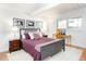 Well-lit bedroom with hardwood floors, art pieces, a desk space and neutral colored carpeting at 1497 S Fairfax St, Denver, CO 80222