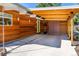 Modern carport featuring wood beams, stylish lighting, and concrete driveway with stone accents at 1497 S Fairfax St, Denver, CO 80222