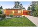 Charming home featuring a modern design, lush lawn, wood details, and covered parking at 1497 S Fairfax St, Denver, CO 80222