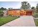 Beautiful modern home with wood siding, ample driveway, and lush green lawn at dusk at 1497 S Fairfax St, Denver, CO 80222