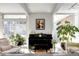 Bright living room featuring a piano, modern decor, and large windows with a view of the outdoors at 1497 S Fairfax St, Denver, CO 80222