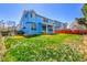 Expansive backyard with vibrant green grass surrounding a bright blue two-story home at 19939 E Belleview Ln, Centennial, CO 80015