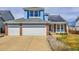 Two-story home with blue siding, brick accents, three-car garage, solar panels and well-maintained lawn and driveway at 19939 E Belleview Ln, Centennial, CO 80015