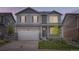 Two story home with a covered porch, a lawn, a two car garage, and grey siding at 4781 Rosette St, Castle Rock, CO 80104
