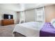 Bedroom with windows, curtains, a dresser and a plush bed with purple accents at 4781 Rosette St, Castle Rock, CO 80104