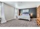 Bedroom with a gray accent wall, carpet and a large window with curtains at 4781 Rosette St, Castle Rock, CO 80104