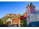 Unique building featuring a tower, a hill with greenery, and diverse storefronts on a sunny day at 4781 Rosette St, Castle Rock, CO 80104