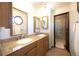 Well-lit bathroom featuring dual sinks, granite countertops, and a glass-enclosed walk-in shower at 1424 Cypress Cir, Lafayette, CO 80026