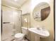 Cozy bathroom featuring a pedestal sink, a unique round mirror, and walk-in shower at 1424 Cypress Cir, Lafayette, CO 80026
