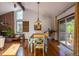 Dining room with hardwood floors, brick fireplace, vaulted ceiling, and sliding door access to the deck at 1424 Cypress Cir, Lafayette, CO 80026