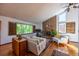 Bright living room showcasing a cozy fireplace, hardwood floors, and large windows with leafy backyard views at 1424 Cypress Cir, Lafayette, CO 80026