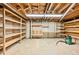 Unfinished basement includes an overhead light, wall storage, shelving, and cement flooring at 1827 Quail St # 8, Lakewood, CO 80215