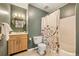 This bathroom features a floral shower curtain, a wood vanity, and an eye-catching geometric mirror at 1827 Quail St # 8, Lakewood, CO 80215